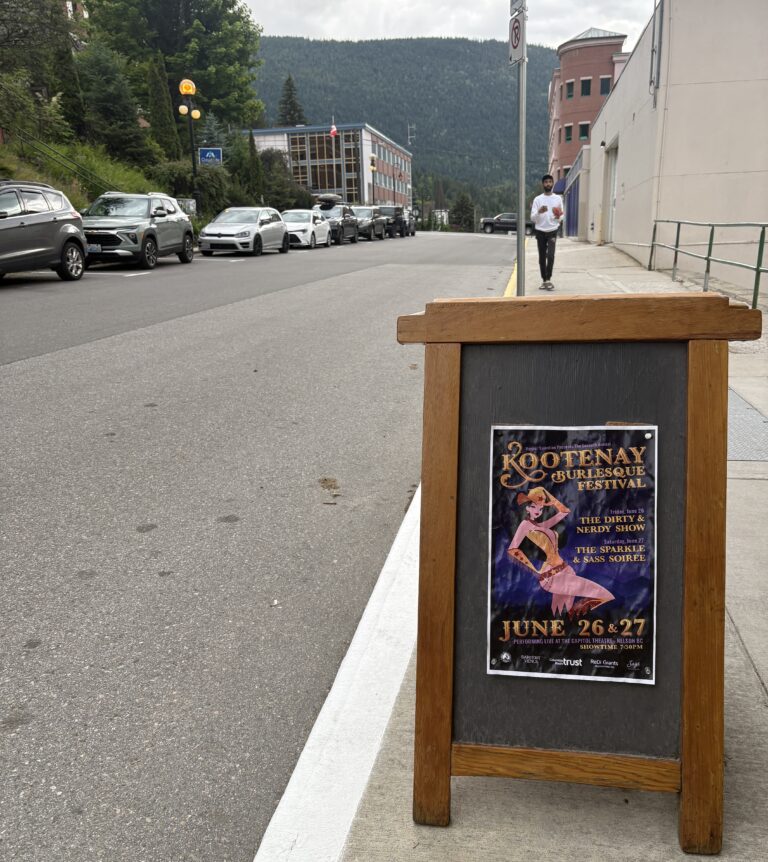 street view of sandwich board with a flyer on it and mountains in the distance